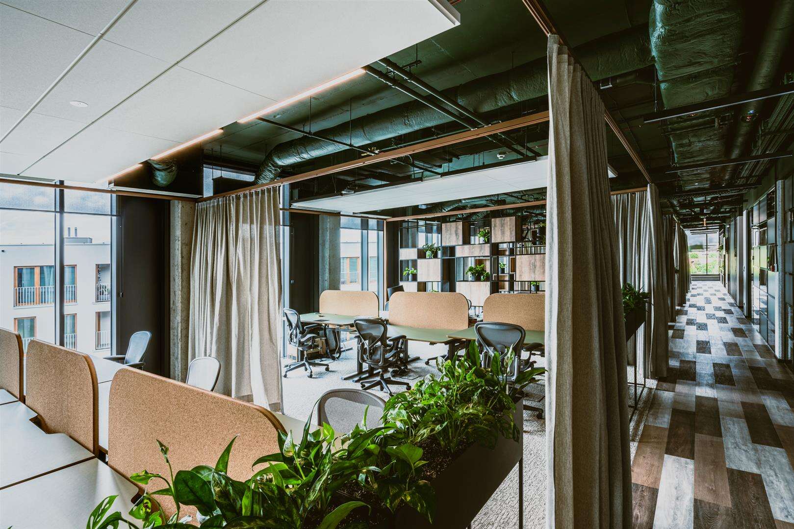 Korkové příčky, rostliny a zeleně natřené stropy vnášejí na pracoviště společností Syzygy a Ars Thanea v polské Varšavě venkovní prostor.