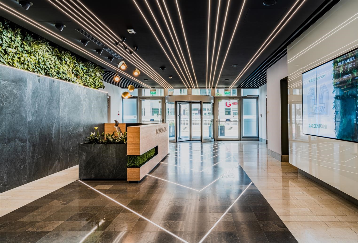 A green wall in reception welcomes visitors to Marynarska Point 2 in Warsaw, Poland